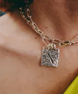 Collar de plata con cadena de eslabones y un dije rectangular texturizado con diseño artesanal.