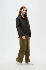 Campera de diseño acolchado con patrón capitoneado, cuello mao y cierre frontal con botones. Presenta mangas largas y un corte recto.