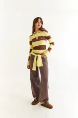 Top de manga larga con diseño de rayas horizontales en tonos negro y marrón, cuello polo con cierre de botones y bordado pequeño en el pecho.