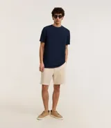 Remera masculina de manga corta, cuello redondo y color marrón oscuro, confeccionada en tejido acanalado de poliéster y algodón.