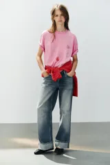 Camiseta oversize de algodón color rosado, con efecto lavado, cuello redondo y manga corta. Presenta aplicaciones de brillos con motivos de Hello Kitty y amigos.