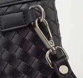 Sobre Denver negro de eco cuero con diseño trenzado y correa de muñeca incorporada.