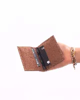 Tarjetero de cuero natural con diseño plegable y compartimentos internos para tarjetas.