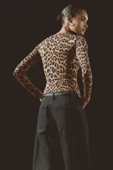 Body de manga larga con escote redondo, confeccionado en punto elástico con estampado de leopardo. Cuenta con refuerzo interior con botones a presión y frente forrado.