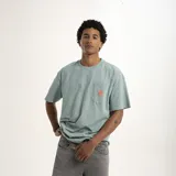 Remera celeste de corte holgado con bolsillo en el pecho y logo estampado en color naranja.