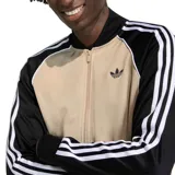Campera adidas Originals SST de corte ajustado, con diseño de inspiración retro en color beige y mangas negras con las clásicas tres tiras blancas de la marca. Cuenta con escote bomber, cierre frontal completo y el logo del trébol bordado en el pecho.