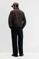 Campera bomber de color marrón oscuro, con cuello, puños y bajo acanalados. Posee cierre frontal y bolsillos laterales con cierre.