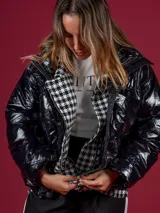 Campera puffer negra de nylon con cuello alto y cierre frontal. Interior con estampado de pata de gallo en blanco y negro.