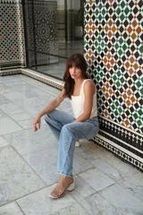 Pantalón de jean celeste de tiro alto y corte recto, con apliques de strass plateados en los laterales.