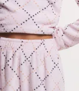 Pijama largo de fleece color rosa claro con estampado de corazones. Incluye un buzo de manga larga con cuello redondo y un pantalón largo con cintura elástica.