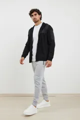 Pantalón jogging de corte slim, con cintura elástica ajustable mediante cordón, puños elásticos en los tobillos, bolsillos laterales con cierre engomado y bolsillo tipo parche lateral.