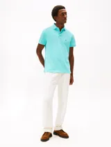 Chomba celeste de Tommy Hilfiger, corte regular, con cuello tipo polo, cartera de dos botones, mangas cortas y logo bordado en el pecho.