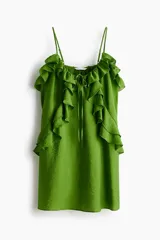 Vestido evasé corto de color verde, confeccionado en mezcla de viscosa con leve brillo. Presenta breteles finos ajustables, escote en U con cordón de ajuste y volados decorativos fruncidos en la parte superior.