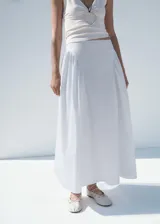 Falda midi de tiro alto con diseño evasé y fruncidos laterales. Confeccionada en algodón con forro interior de algodón y cierre de cremallera lateral.