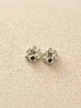 Par de dijes de plata con diseño irregular y orgánico en forma de flor, con incrustaciones de zirconias. Diseñados para ser utilizados como complemento en aros.