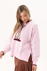 Buzo de punto rosado con diseño frontal de velero, cuello redondo y puños en contraste color bordó.