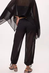 Pantalón ancho de seda color amarillo, estilo parachute o globo, con talle alto y cordones ajustables en los tobillos.