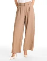 Pantalón tipo palazzo de corte ancho y fluido, confeccionado en tejido sastrero. Presenta tiro alto con doble abotonadura frontal, pinzas decorativas y cintura elástica en la parte posterior. Incluye bolsillos laterales funcionales.