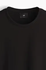 Remera negra de manga corta, cuello redondo y corte ajustado (slim fit), confeccionada en punto suave de algodón pima.