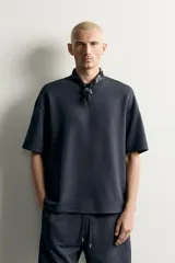 Sudadera relaxed fit confeccionada en tejido interlock de algodón con elasticidad, cuello redondo y manga corta, de color negro.