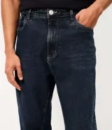 Pantalón de jean corte recto, color azul oscuro, con diseño clásico de cinco bolsillos, cierre frontal con botón y cremallera, y trabillas para cinturón.