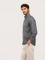 Camisa de hombre de corte regular fit, color gris oscuro, confeccionada en algodón con acabado vintage de tintado en prenda. Cuenta con cuello button-down, cierre frontal de botones, manga larga y logo bordado en el pecho.