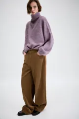 Jersey de punto con cuello alto y cierre frontal de cremallera metálica, de manga larga con puños ajustados y diseño holgado.