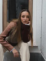 Buzo tejido de punto color crema con cuello alto y mangas largas con rayas horizontales en verde y lila.