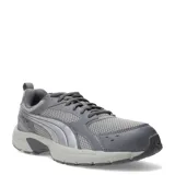 Championes Puma Milenio Tech Lt de color gris, con diseño de inspiración retro, parte superior de malla transpirable y detalles superpuestos en material sintético con la característica franja lateral de la marca en tono plateado. Cuenta con cordones grises y suela de goma amortiguada.