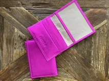 Tarjetero Breton de cuero vacuno color fucsia, con ranuras para tarjetas y bolsillo exterior.