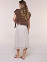 Falda midi evasé de mezcla de lino color beige, con abotonadura frontal completa, pretina elastizada en la espalda, pespuntes horizontales en contraste y terminación bordada en el ruedo. Incluye forro interior.