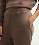 Pantalón boot cut de algodón con felpa y cintura elástica, en color beige.