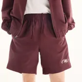 Short New Balance modelo Trackside, color bordó, confeccionado en felpa francesa suave con cintura elástica, bolsillos laterales y logotipo bordado en el muslo izquierdo.