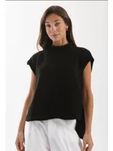 Chaleco tejido de punto con cuello levemente alto y silueta amplia. Presenta un diseño con aberturas laterales y un largo asimétrico, siendo más corto en el frente y más largo en la espalda.