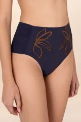 Calzón de bikini alto azul marino con motivos florales dorados, recogidos en los costados y bordado con chaquira en la parte frontal.