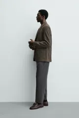 Pantalón de vestir regular fit color negro, confeccionado en tejido con mezcla de lana y elasticidad. Cuenta con cintura elástica, bolsillos frontales, bolsillos traseros de vivo con botón, y cierre frontal con cremallera y botón.