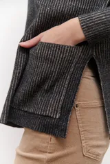 Buzo de tejido de punto acanalado en color beige, con cuello redondo, mangas largas y un bolsillo frontal aplicado en la parte inferior.