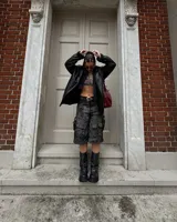 Bota negra de caña media con hebilla lateral y cadena decorativa.