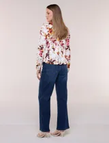 Blazer entallado de corte formal y estructurado, confeccionado en algodón con elastano. Presenta solapa clásica, cierre frontal con un botón a tono, bolsillos falsos tipo ojal en la cintura y mangas largas de corte recto. Cuenta con un diseño estampado floral en tonos rojo, bordó y amarillo sobre base blanca.
