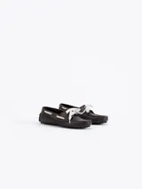 Mocasín de cuero vacuno con efecto gastado, diseño de la colaboración Jazmín Chebar x Guido. Presenta detalles de picado en laterales y capellada, con cordones blancos y suela de goma con relieve.