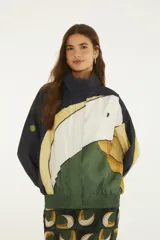 Campera corta Vento Tuca Tropical ligera de cuello alto y cierre frontal, con diseño colorido inspirado en la naturaleza.