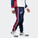 Pantalón de jogging azul marino de felpa, con franjas laterales en rojo y blanco. Presenta el escudo del Club Nacional de Football en el muslo derecho y el logo de Umbro en el izquierdo, con cintura elástica y cordón de ajuste.