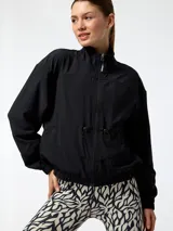 Campera cortavientos Bsoul de color negro, con cuello alto, cierre frontal y cordón ajustable en la cintura.