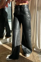 Pantalón de cuero negro, estilo recto o ancho, con textura de napa.