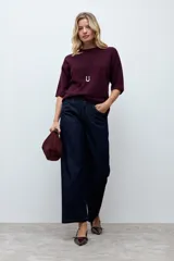 Sweater de punto color ciruela, con cuello redondo, mangas 3/4 y corte holgado.