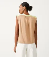 Blusa sin mangas color beige con detalle en los hombros y cuello color verde claro.