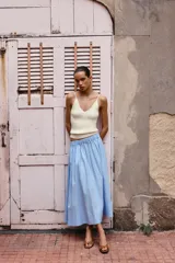 Falda midi celeste de popelina con cintura elástica y bolsillos laterales ocultos.