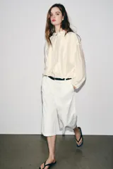 Chaqueta bomber de cuello subido y manga larga, con acabado satinado en color beige. Presenta pliegues frontales, bolsillos laterales ocultos en costura y cierres elásticos en puños y cintura. Cierre frontal con cremallera.