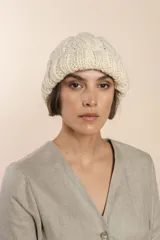 Gorro tejido a mano con diseño de ochos, color marrón y blanco jaspeado.