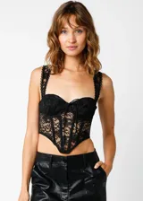 Top tipo corset confeccionado en encaje negro, con estructura de varillas, copas preformadas y breteles anchos con detalle de puntilla. Presenta un diseño entallado con terminación en punta en la parte inferior.